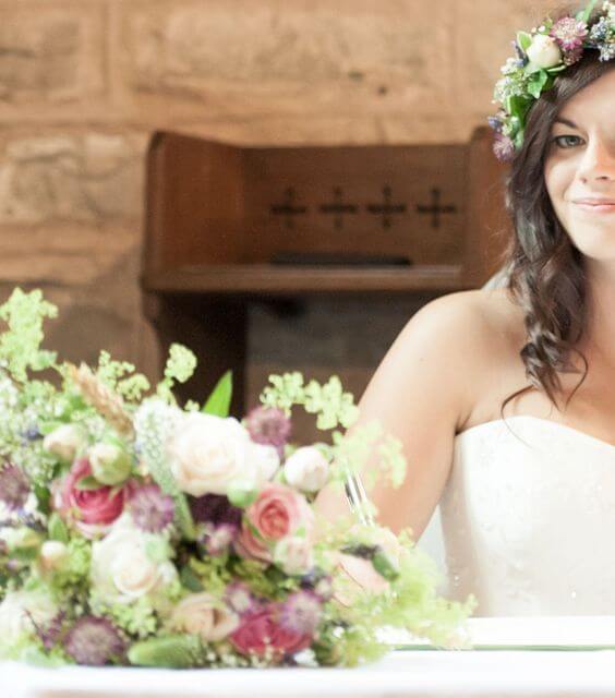 Bride with bouquet and flower crown in church